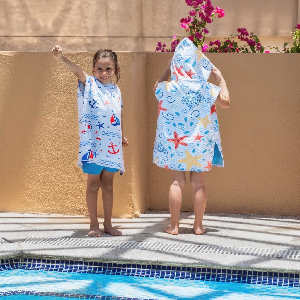 Boy and girl wearing La Toalla beach poncho for kids