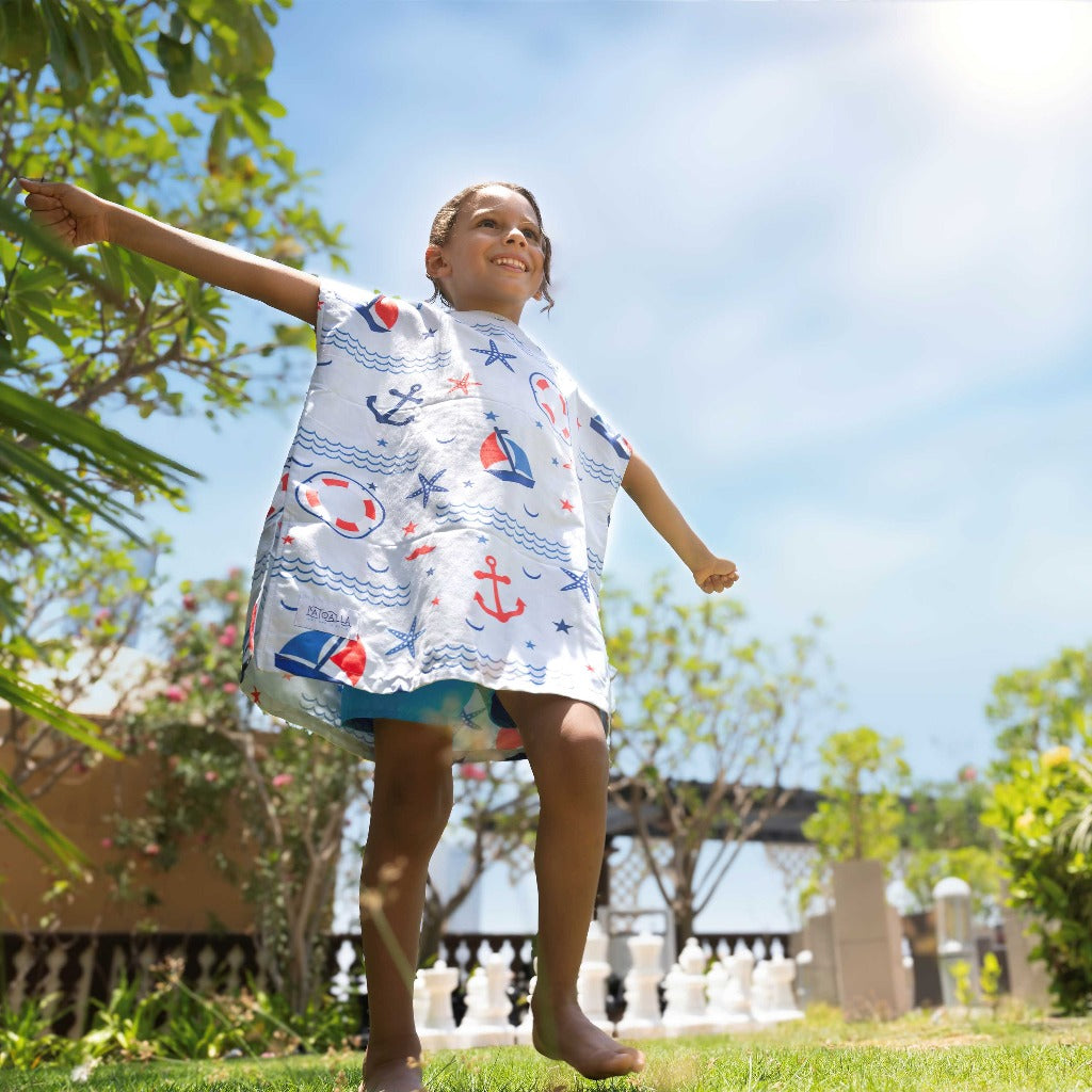 Boy wearing La Toalla beach poncho for kids